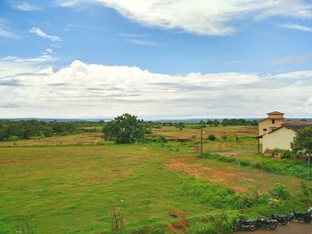 Scenic view of grassy field against sky
