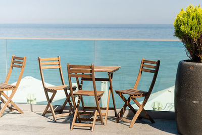 Wooden chairs and table overlooking spectacular seaside view