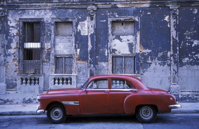 Red car against abandoned building