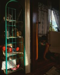 Rear view of man seen through glass window at home