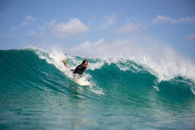 Man surfing in sea against sky
