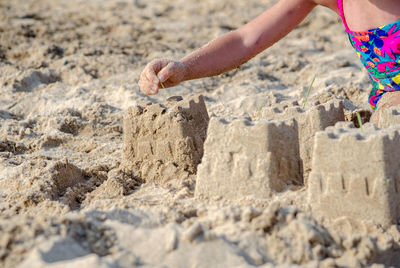 Child is building castles out of sand on a beach