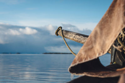 Close-up of fishing boat in sea against sky