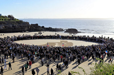 High angle view of people on sea shore against sky