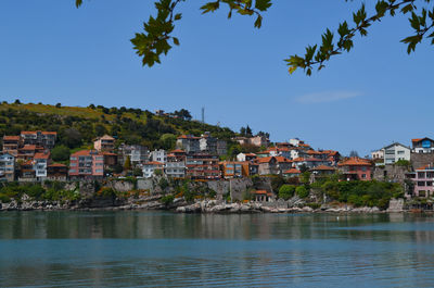 Houses by river against sky in town