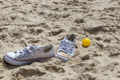 High angle view of shoes on sand at beach