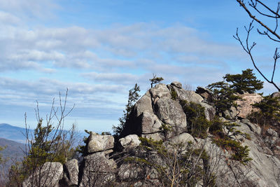 Rock formation by sea against sky
