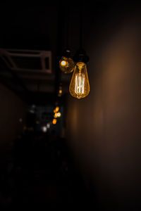 Low angle view of illuminated pendant light hanging from ceiling