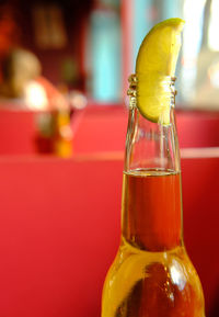 Close up of a bottle of beer with a lime slice inserted.