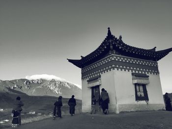 People at temple against clear sky