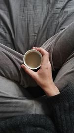 Low section of woman holding coffee cup