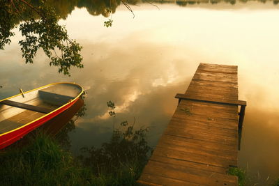 Boat moored on lake against sky