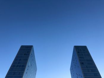 Low angle view of modern buildings against clear blue sky