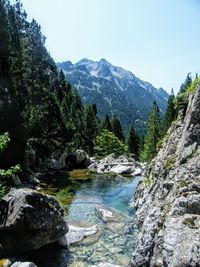 Scenic view of river amidst mountains against sky