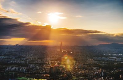 Aerial view of buildings against cloudy sky during sunset