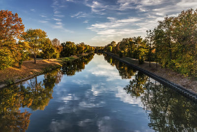 Scenic view of river amidst trees against sky