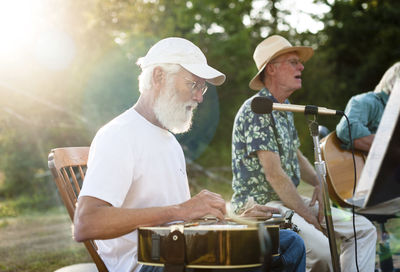 Man singing while friend playing guitar in yard