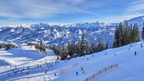 People skiing on snowcapped mountain against sky