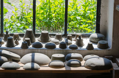 High angle view of ancient utensils by window at museum