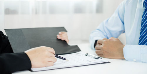 Midsection of doctor explaining to patient at clinic