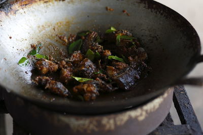 Cooking thai cuisine, spicy catfish with red curry paste on a hot wok frying pan