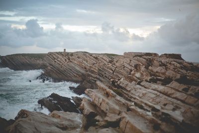 Scenic view of rocks on beach against sky