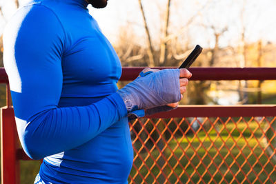 Side view of man holding mobile phone