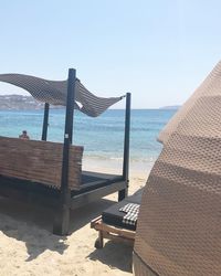 Deck chairs on beach against clear sky