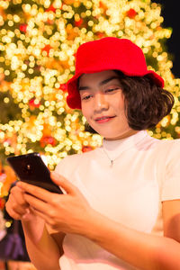 Portrait of smiling young woman using mobile phone