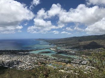 Aerial view of townscape by sea against sky