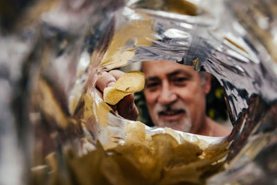 Close-up portrait of man holding leaf