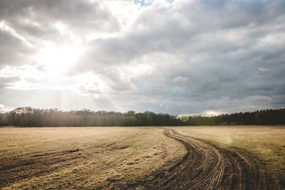 Scenic view of grassy field against cloudy sky