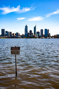 River by buildings in city against sky