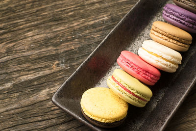 Colorful and delicious french macaron cookies varieties on a wooden table