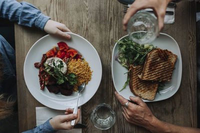 Midsection of woman holding food on table