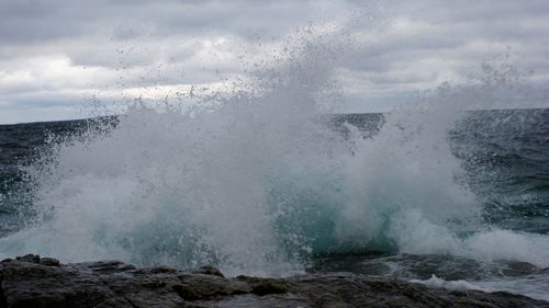 View of waves breaking against the sky