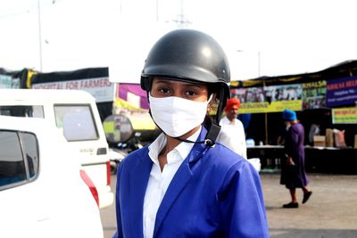 Close-up portrait of young woman wearing helmet outdoors