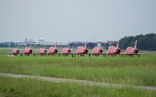 Side view of people on countryside landscape against clear sky