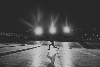 Woman on footpath in city at night