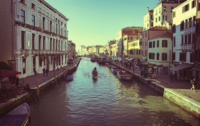 Boats in canal along buildings