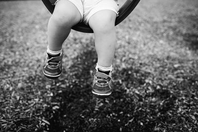 Low section of girl swinging at playground