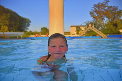 Little girl in swimming pool. portrait of little cute girl in the swimming pool. sunny summer day