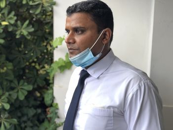 Portrait of young man with face mask looking away