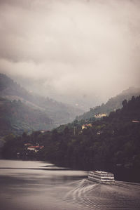 Scenic view of lake by mountains against sky