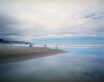 View of beach against cloudy sky