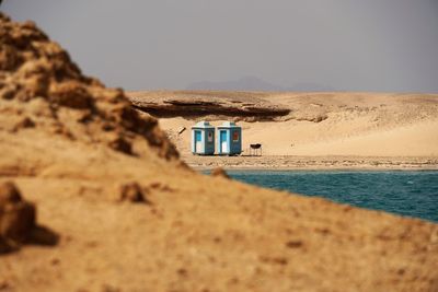 Lifeguard hut on sand at beach against clear sky