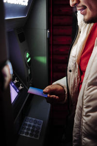 Young man using debit card at atm