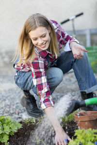 Young woman planting plant, stockholm, sweden
