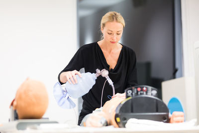 Doctor performing treatment on crash test dummy at hospital