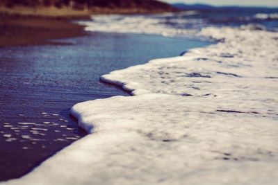 Close-up of sand at beach against sky